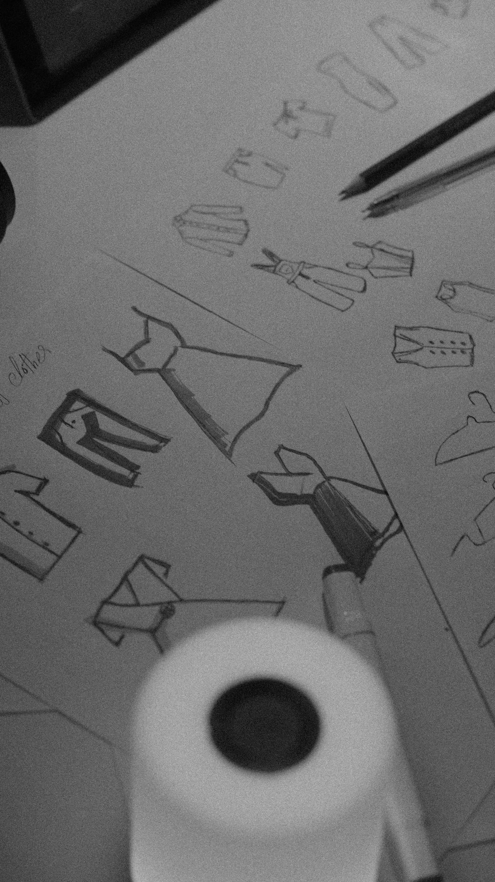 Pencil sketches of garments on a sheet of paper.