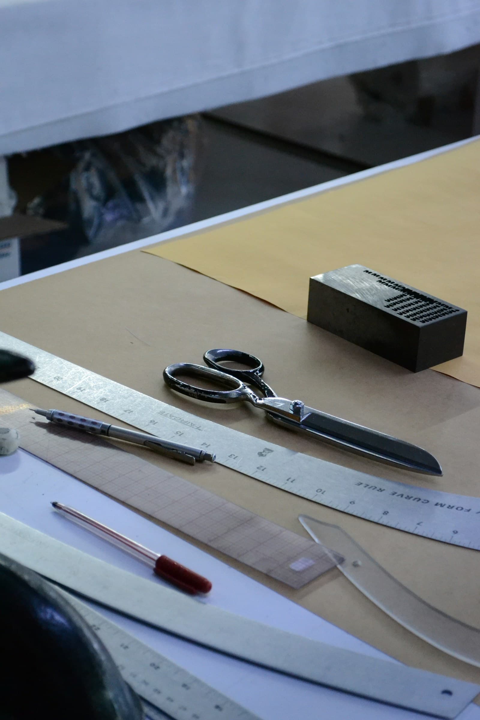 Scissors, rulers and French curves on pattern paper.